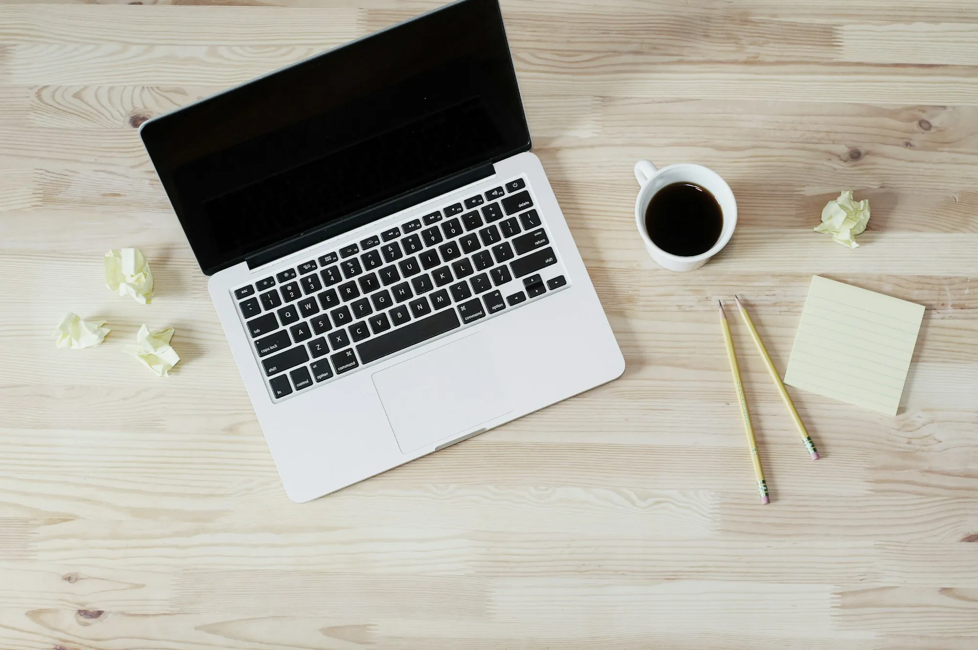 Laptop, coffee and notes on a light wood desk