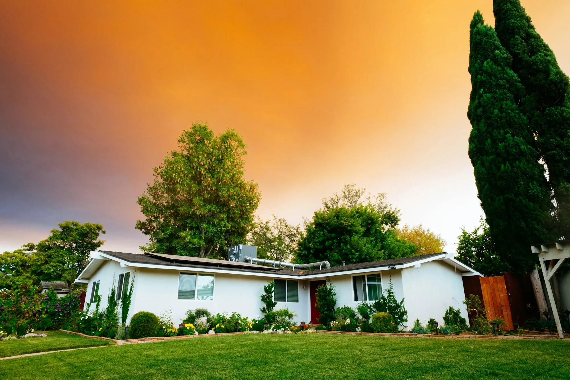 White single-story house under a colorful evening sky