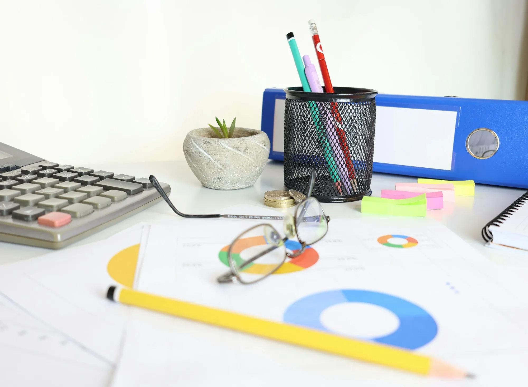Office desk with a calculator, charts and pencils, illustrating the paperwork of how escrow works for a home sale in Exeter