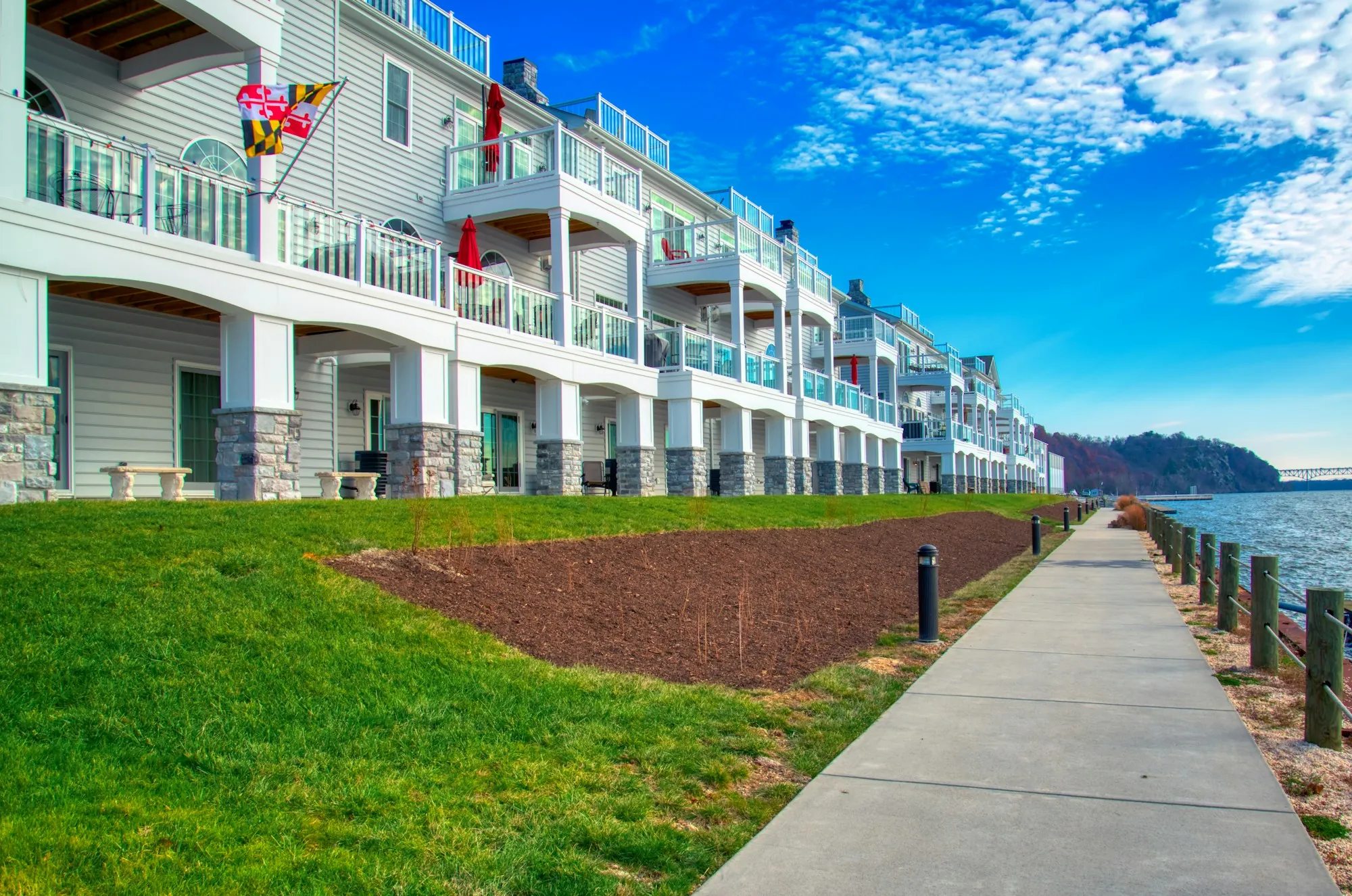 Waterfront townhomes with balconies along a walking path