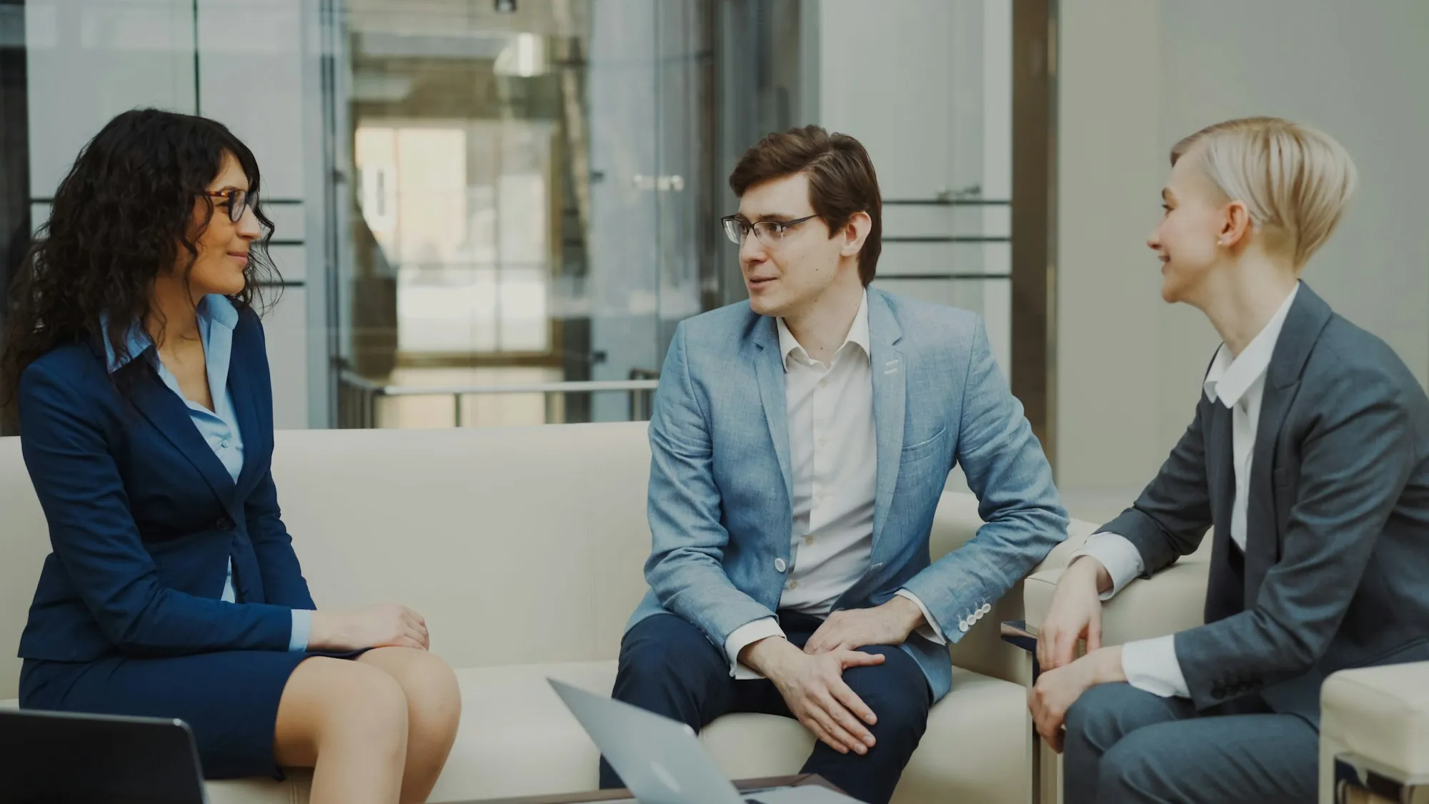 Three professionals meeting and talking in an office